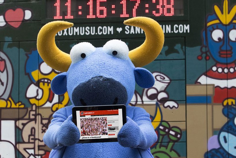 Mister Testis, el toro azul de Kukuxumusu, muestra la nueva web Sanfermin.com en su tablet.