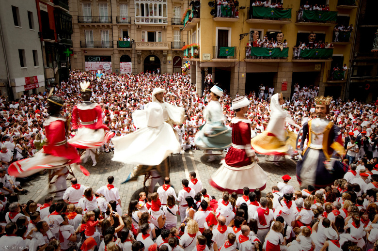 Imágenes de los gigantes bailando con las faldas al aire en plena plaza del Ayuntamiento de Pamplona por Sanfermin. Una foto llena de colorido y movimiento.